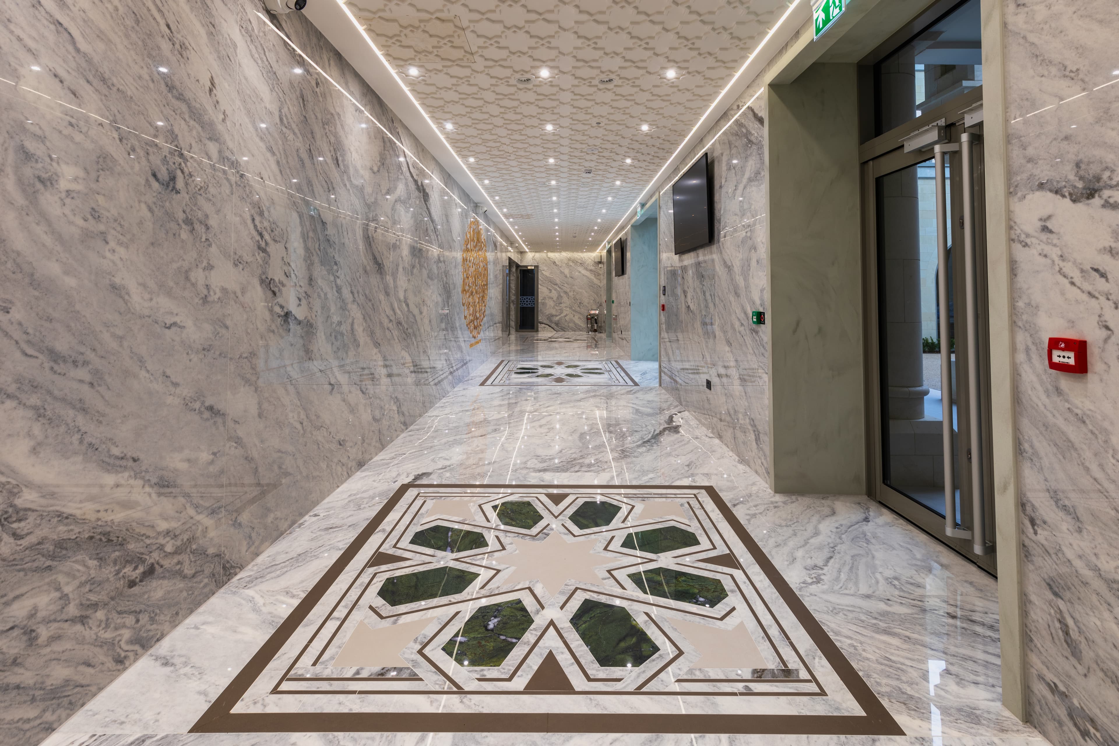 A green and gold eight-point star inlaid into the marble corridor floor